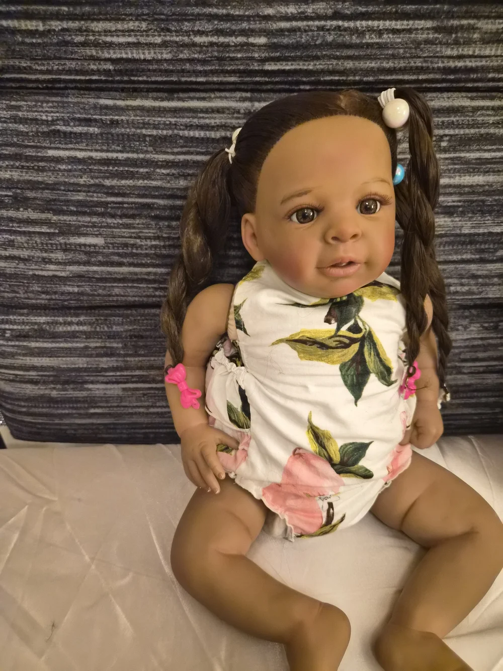 Reborn brown baby doll with pink and white floral outfit